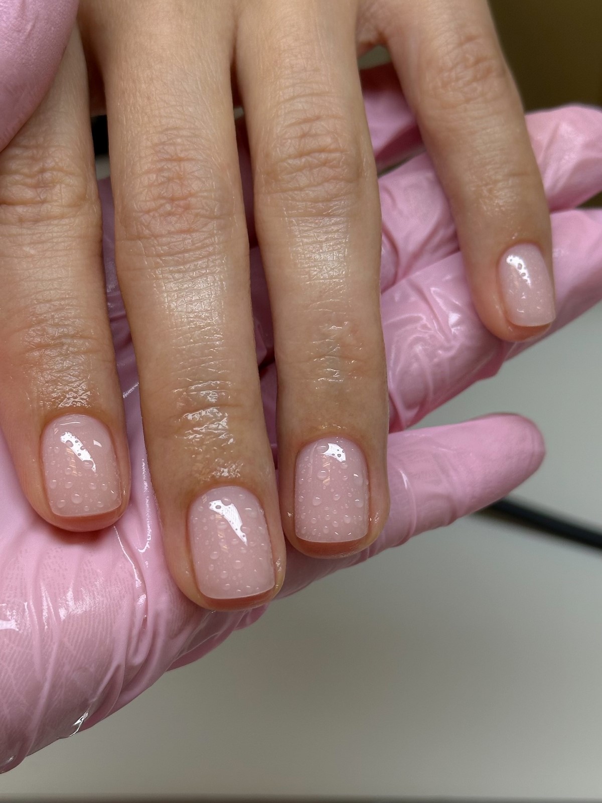 Светлый прозрачный маникюр с мелким сиянием и glossy-финишем на коротких ногтях