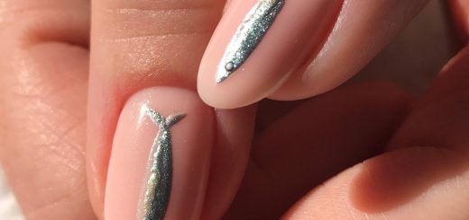 Серебристые сардины на молочно-розовых миндальных ногтях крупным планом